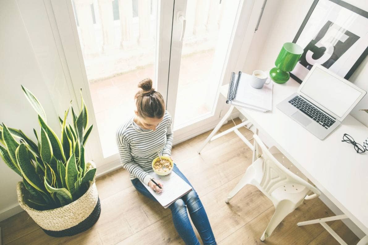 A young women sitting on the floor while taking notes