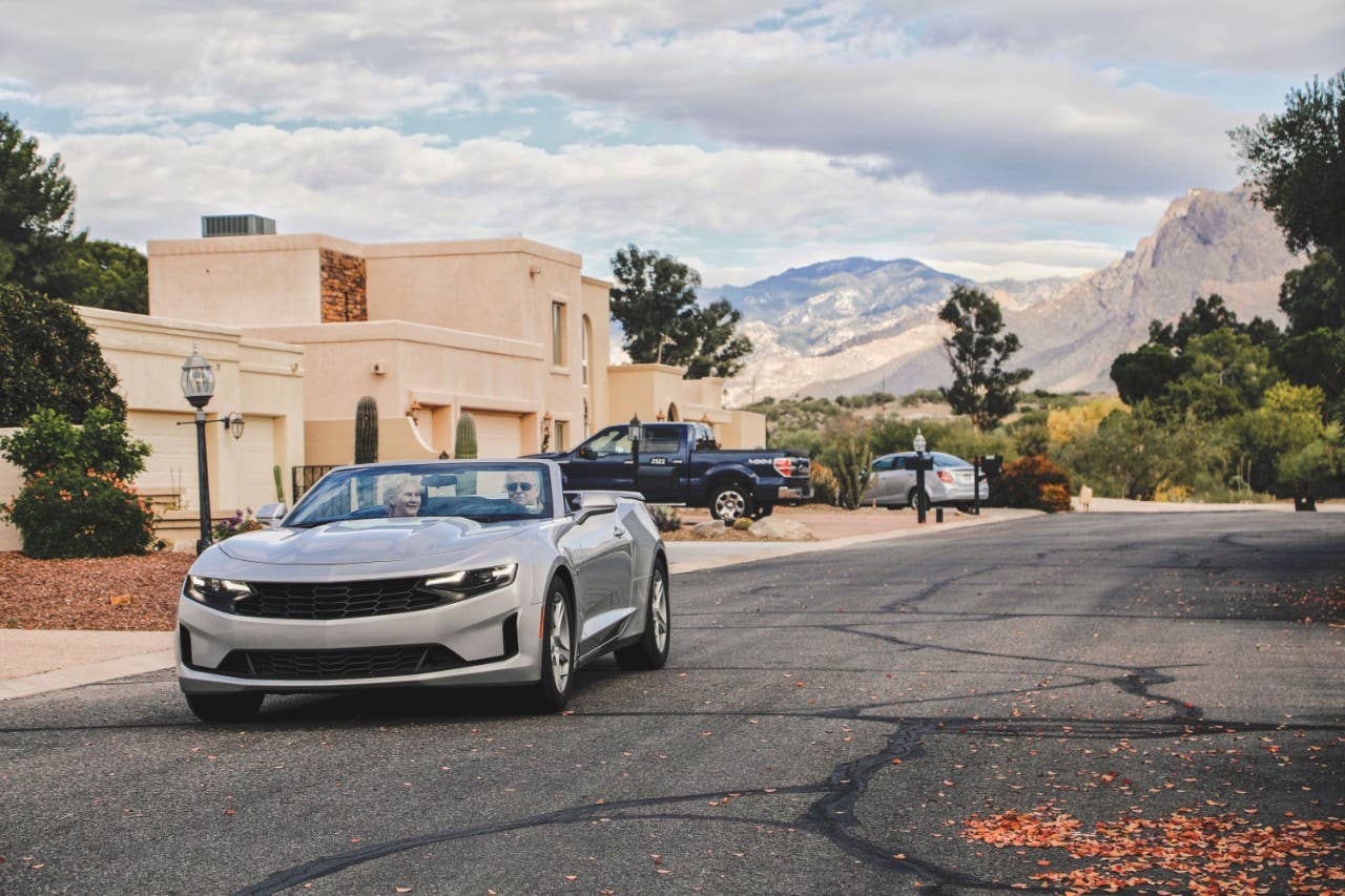 Retired couple driving convertable